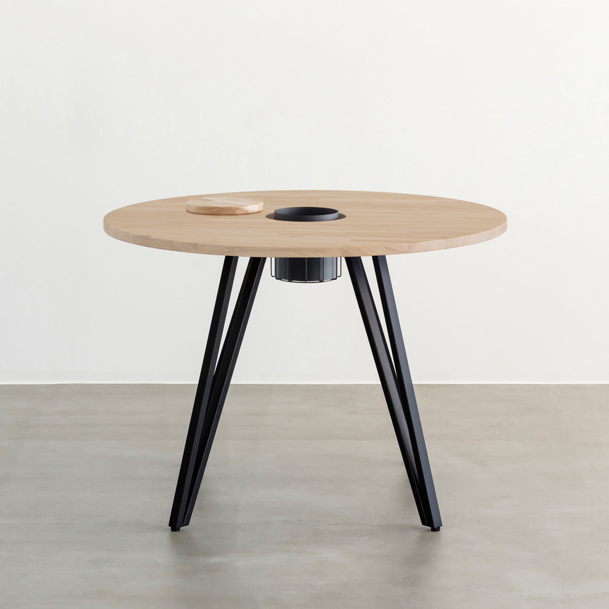 KANADEMONOのワイヤーバスケット付きのラバーウッド材アッシュグレーのラウンド天板にマットブラックのトライアングル鉄脚を組み合わせたカフェテーブル（正面）