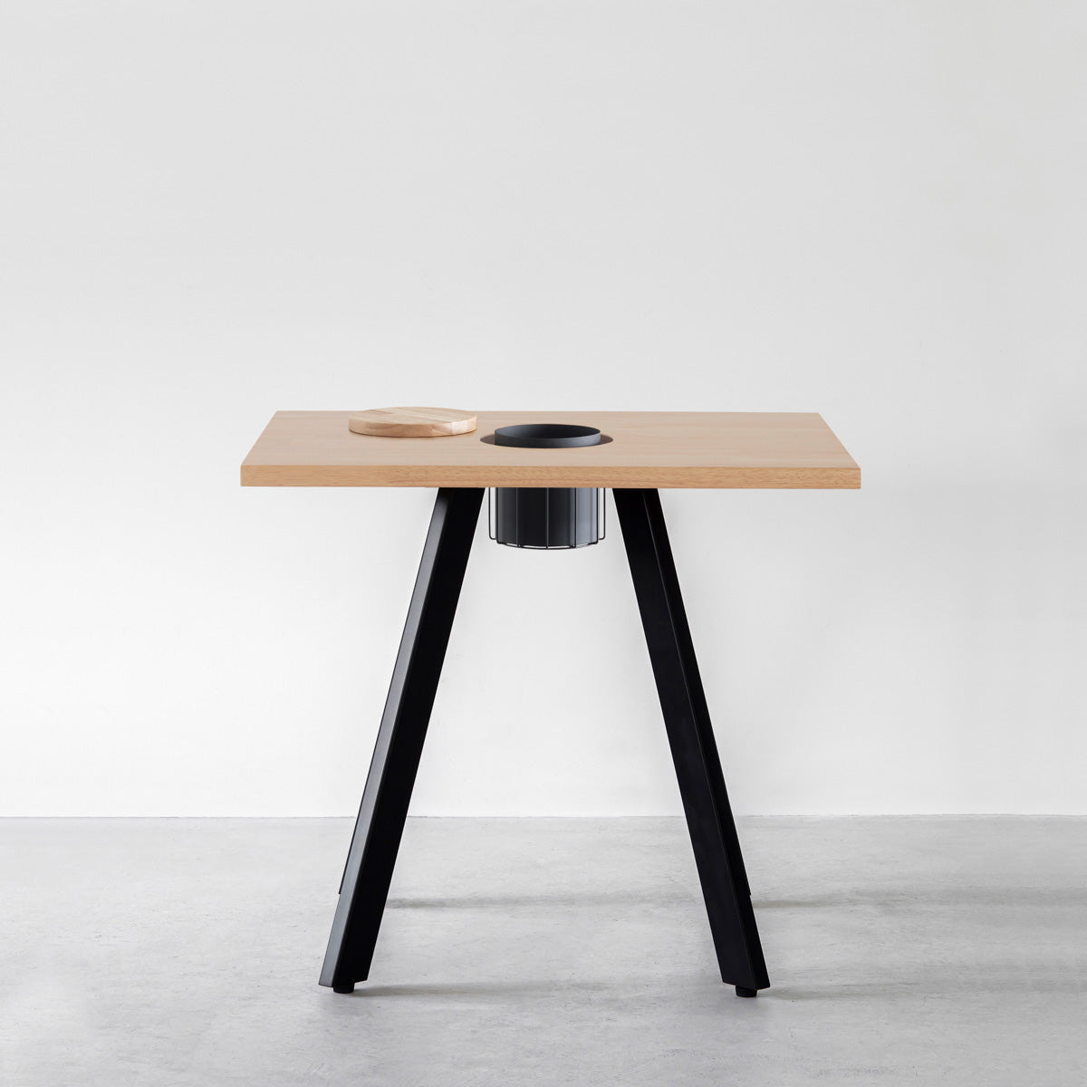 KANADEMONOのワイヤーバスケット付きのスクエアラバーウッド材アッシュグレーカラー天板にマットブラックの4pinアイアン脚を組み合わせたカフェテーブル（正面）