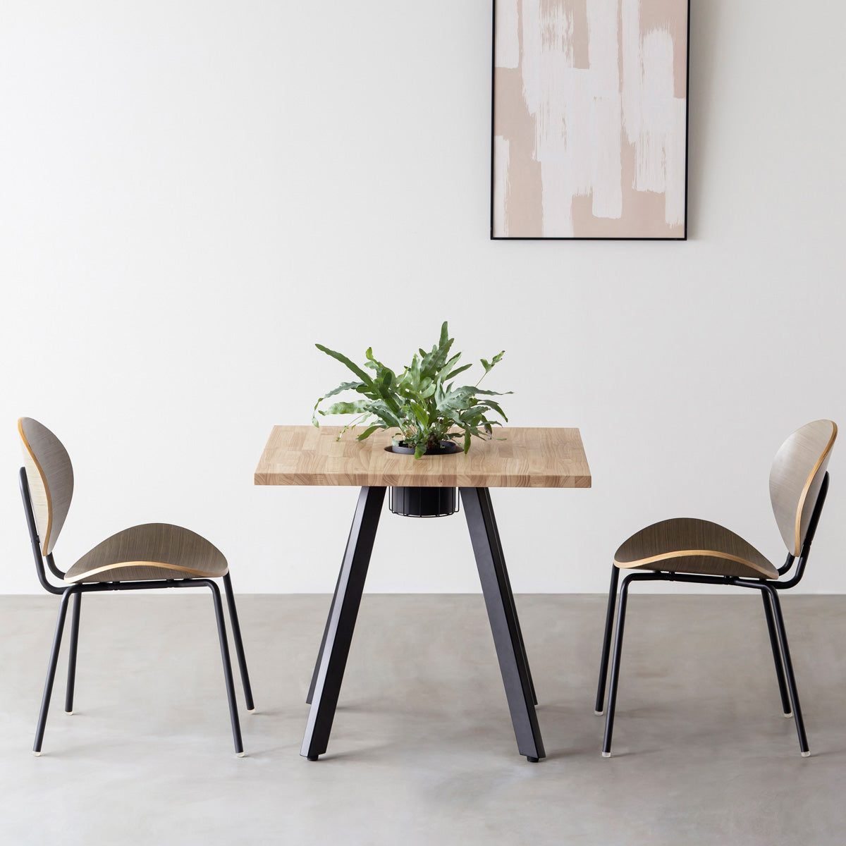 KANADEMONOのワイヤーバスケット付きのスクエアラバーウッド材アッシュグレーカラー天板にマットブラックの4pinアイアン脚を組み合わせたカフェテーブル（使用例）