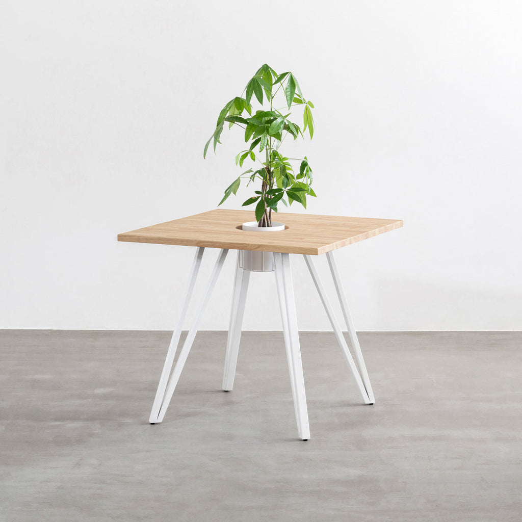 KANADEMONOのワイヤーバスケット付きのラバーウッド材アッシュグレーのスクエア天板にマットホワイトのトライアングル鉄脚を組み合わせたカフェテーブル（バスケット使用例）