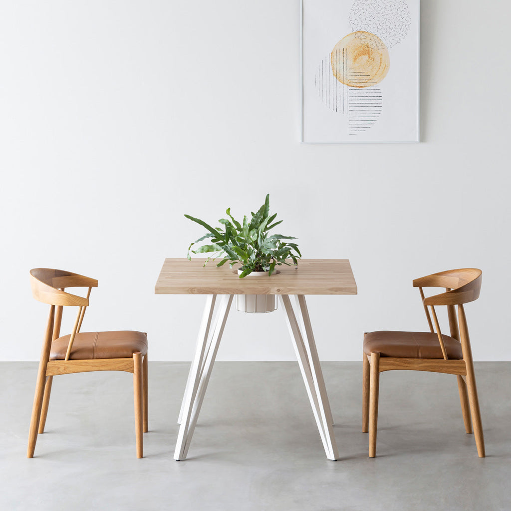 KANADEMONOのワイヤーバスケット付きのラバーウッド材アッシュグレーのスクエア天板にマットホワイトのトライアングル鉄脚を組み合わせたカフェテーブル（使用例）