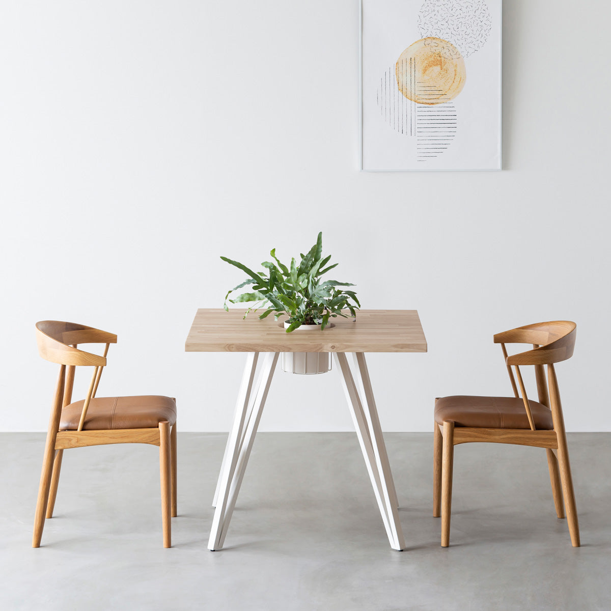 KANADEMONOのワイヤーバスケット付きのラバーウッド材アッシュグレーのスクエア天板にマットホワイトのトライアングル鉄脚を組み合わせたカフェテーブル（使用例）