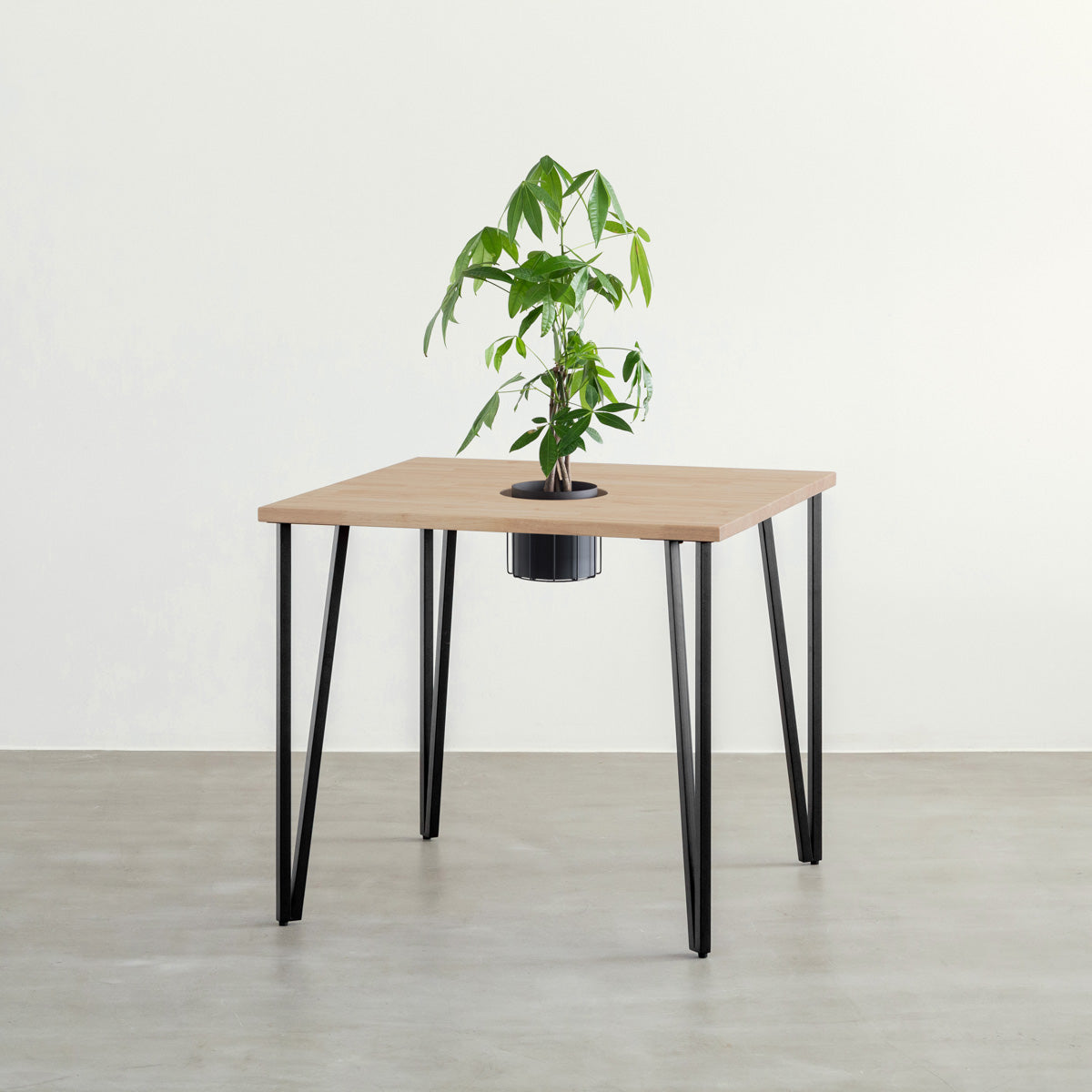 KANADEMONOのワイヤーバスケット付きのラバーウッド材アッシュグレーのスクエア天板にマットブラックのトライアングルStraight鉄脚を組み合わせたカフェテーブル（バスケット使用例）