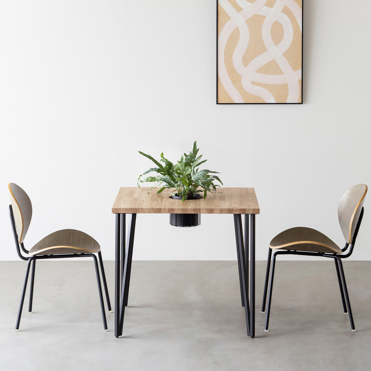 KANADEMONOのワイヤーバスケット付きのラバーウッド材アッシュグレーのスクエア天板にマットブラックのトライアングルStraight鉄脚を組み合わせたカフェテーブル（使用例）