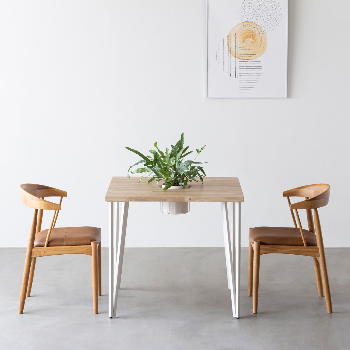 KANADEMONOのワイヤーバスケット付きのラバーウッド材アッシュグレーのスクエア天板にマットホワイトのトライアングルStraight鉄脚を組み合わせたカフェテーブル（使用例）