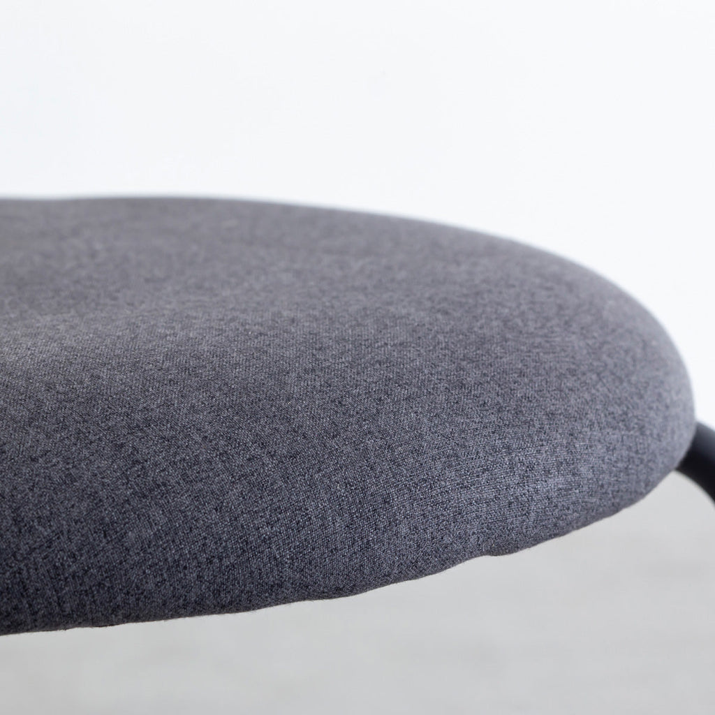 KANADEMONOのラタン調の楕円形の背もたれ、ダークグレーのファブリック座面、ブラックスチール脚が特徴のモダンなダイニングチェア（座面）