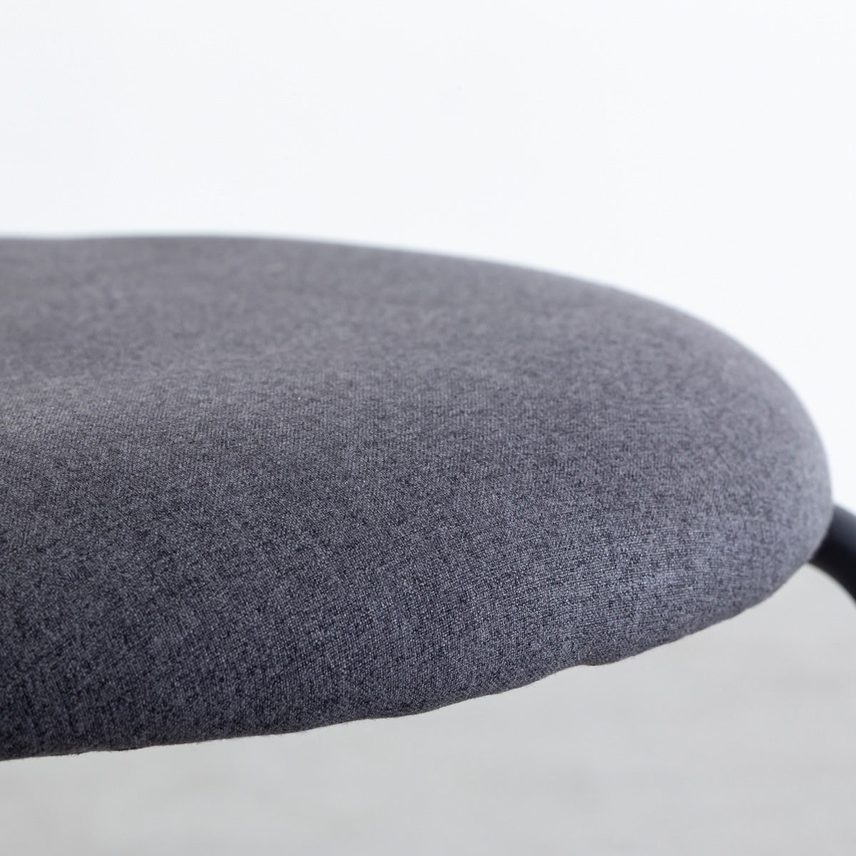 KANADEMONOのラタン調の楕円形の背もたれ、ダークグレーのファブリック座面、ブラックスチール脚が特徴のモダンなダイニングチェア（座面）