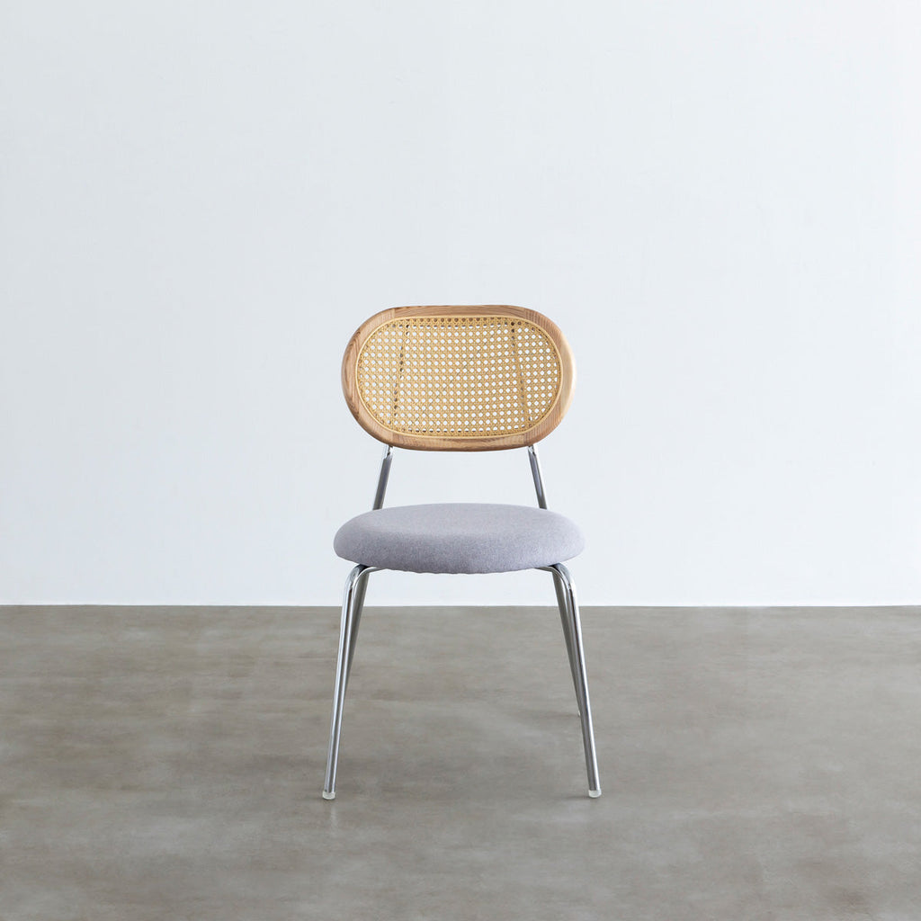 KANADEMONOのラタン調の楕円形の背もたれ、ライトグレーのファブリック座面、シルバースチール脚が特徴のモダンなダイニングチェア（正面）