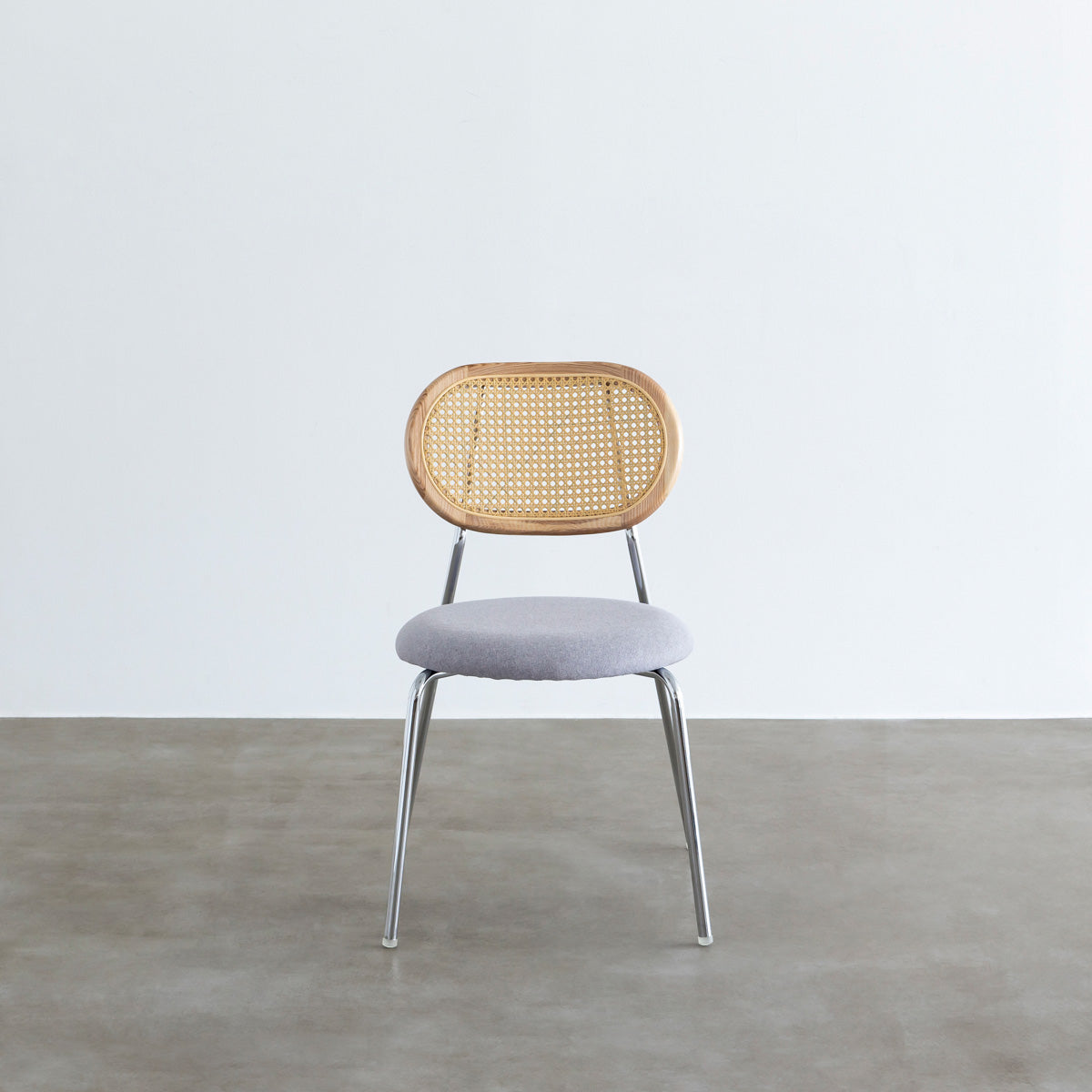 KANADEMONOのラタン調の楕円形の背もたれ、ライトグレーのファブリック座面、シルバースチール脚が特徴のモダンなダイニングチェア（正面）