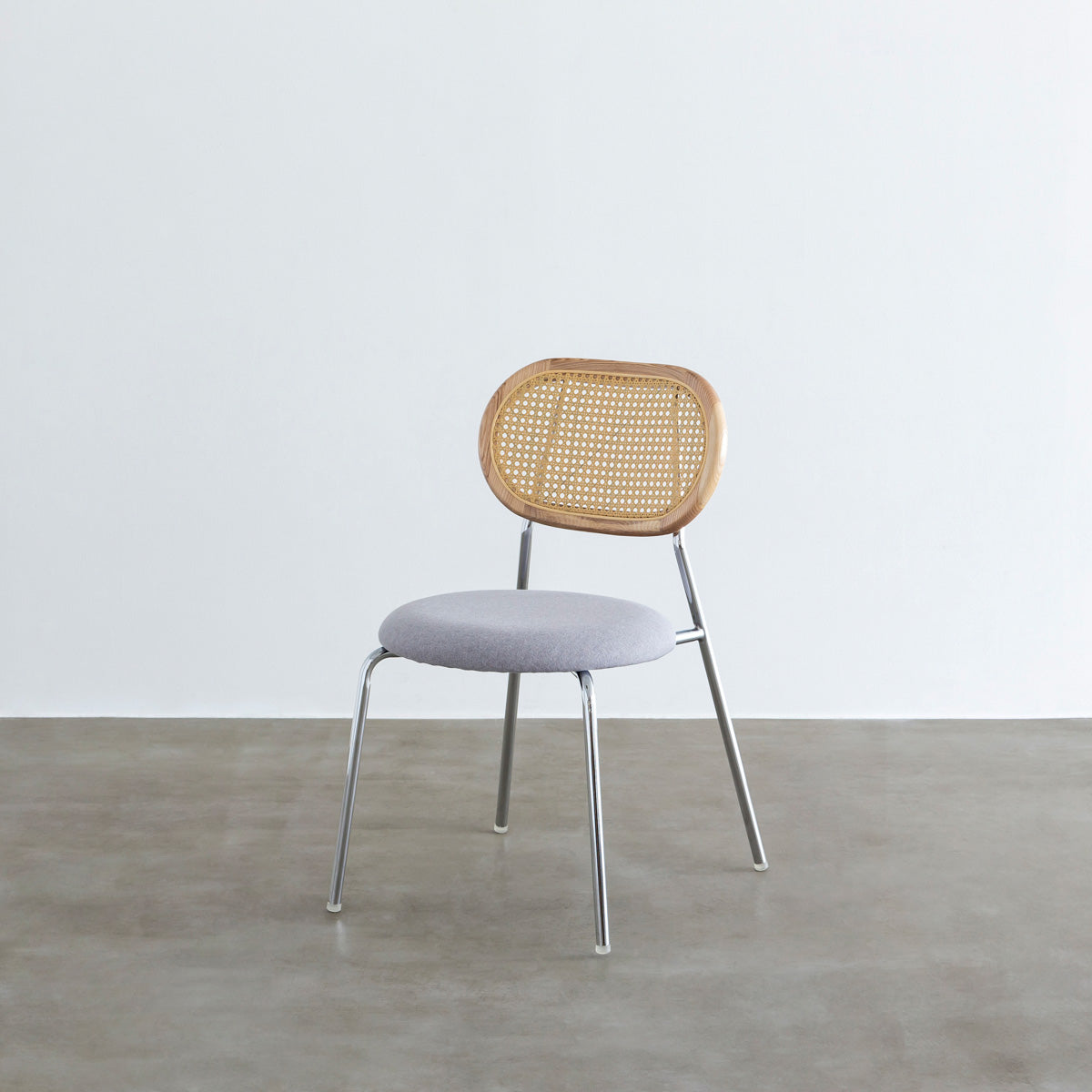 KANADEMONOのラタン調の楕円形の背もたれ、ライトグレーのファブリック座面、シルバースチール脚が特徴のモダンなダイニングチェア