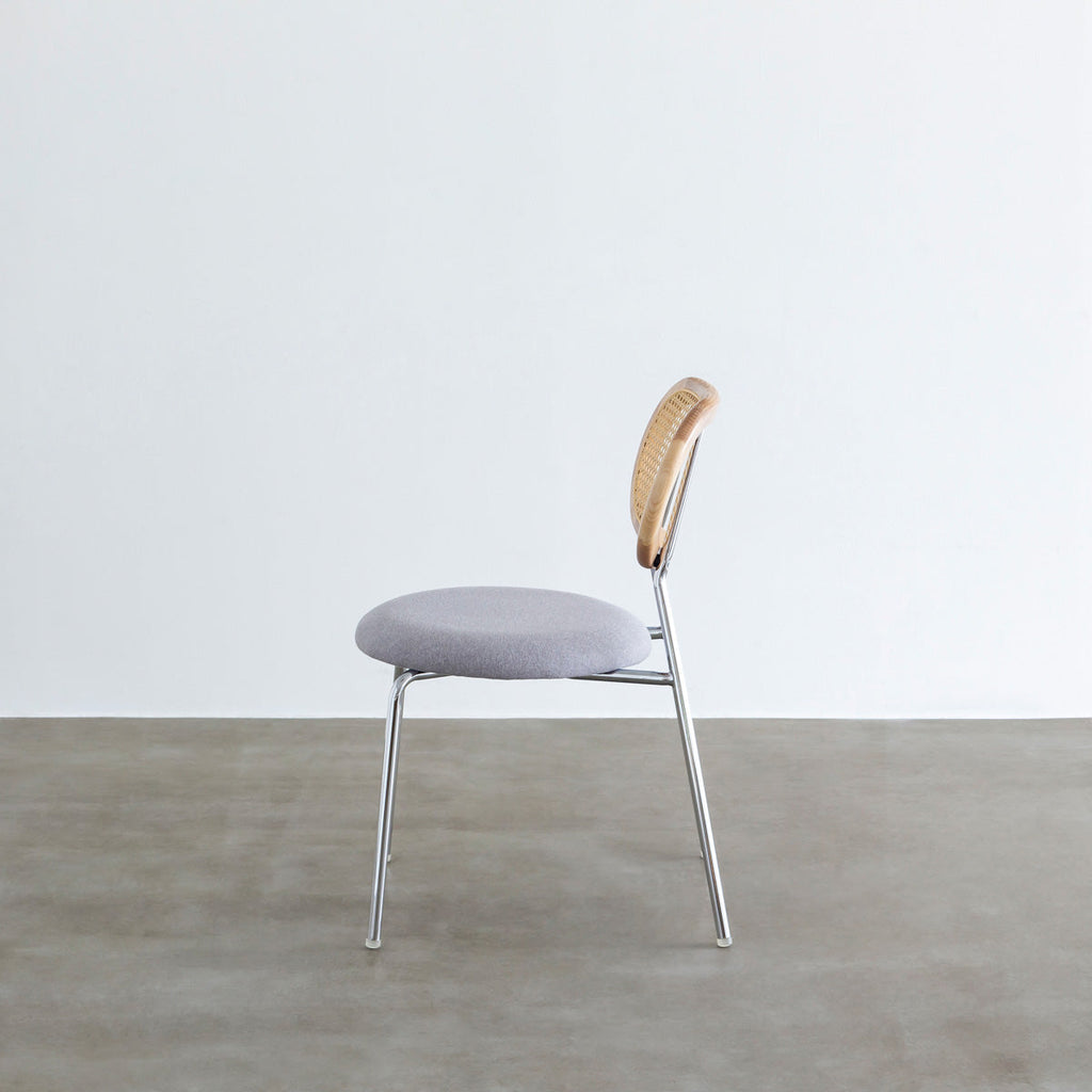 KANADEMONOのラタン調の楕円形の背もたれ、ライトグレーのファブリック座面、シルバースチール脚が特徴のモダンなダイニングチェア（側面）