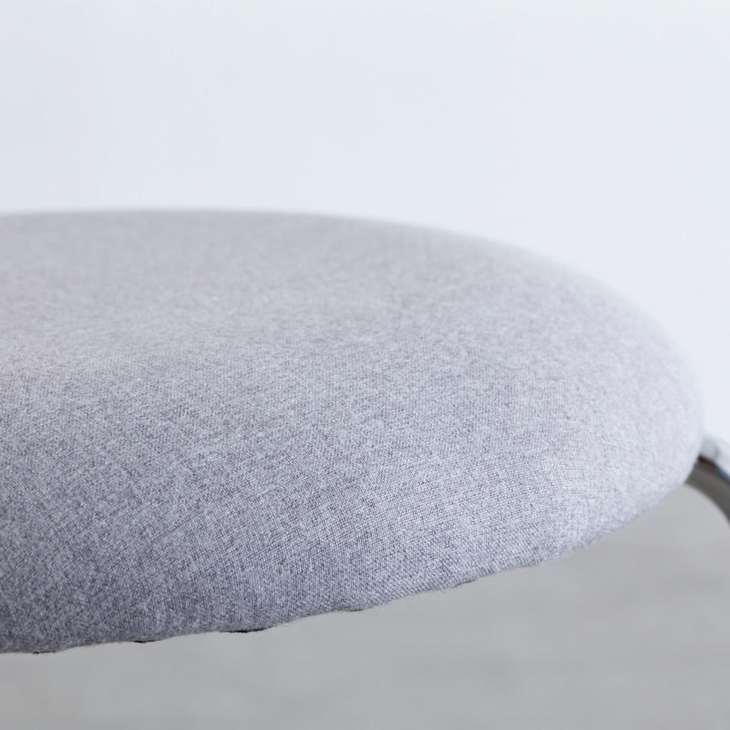 KANADEMONOのラタン調の楕円形の背もたれ、ライトグレーのファブリック座面、シルバースチール脚が特徴のモダンなダイニングチェア（座面）