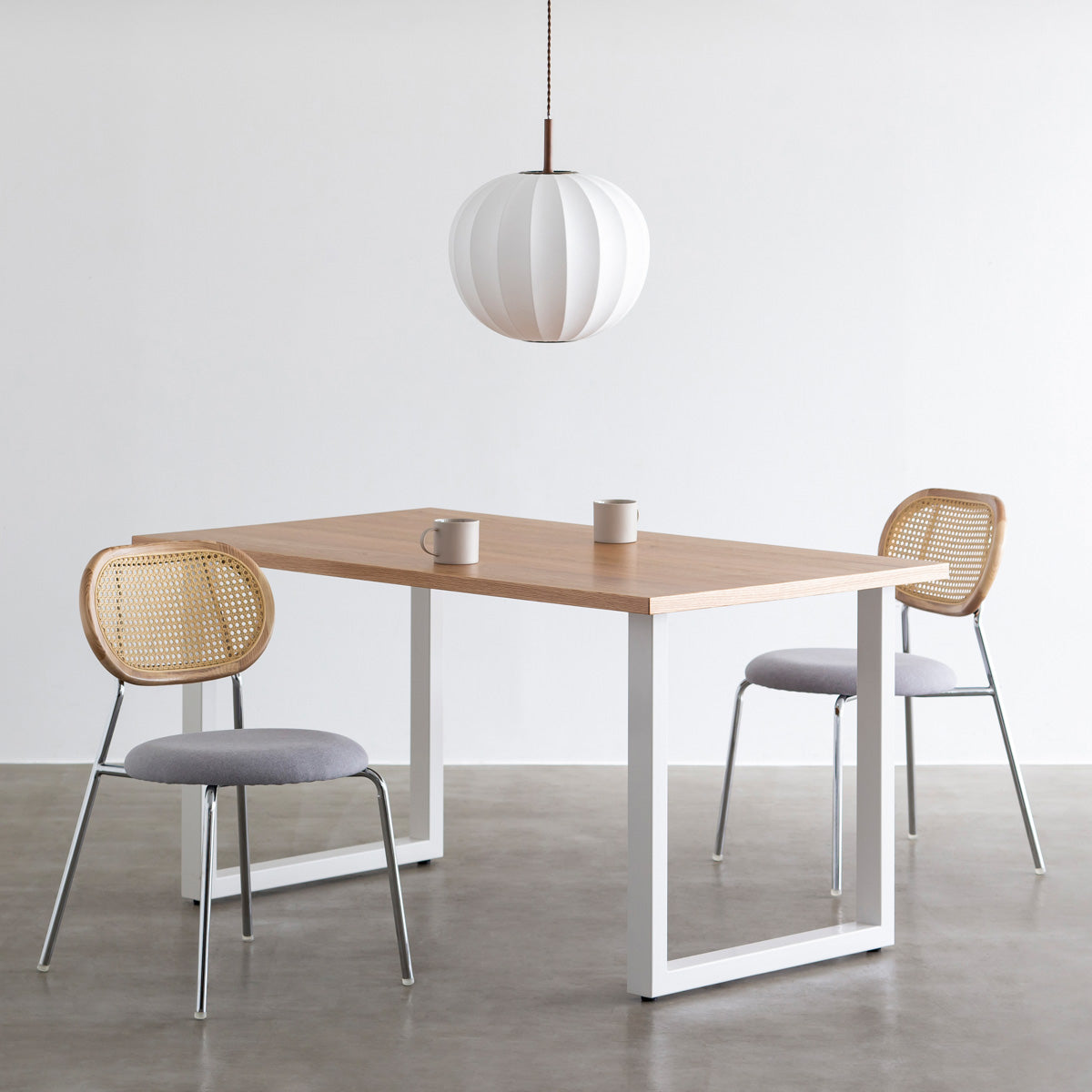 KANADEMONOのラタン調の楕円形の背もたれ、ライトグレーのファブリック座面、シルバースチール脚が特徴のモダンなダイニングチェア（使用例2）