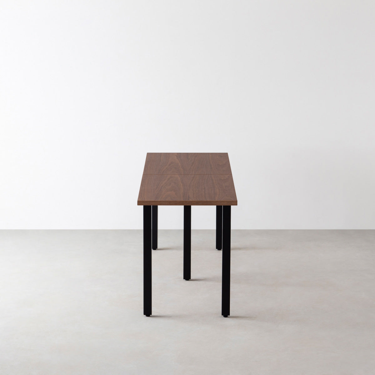 Kanademonoのウォルナット突板天板とマットブラックの角柱鉄脚を組み合わせた奥行スリムタイプの特寸大型テーブル（側面）