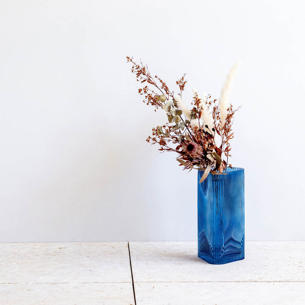 かなでもののブルーのガラスを使用した口が広く使いやすい三角形のフラワーベースの使用例