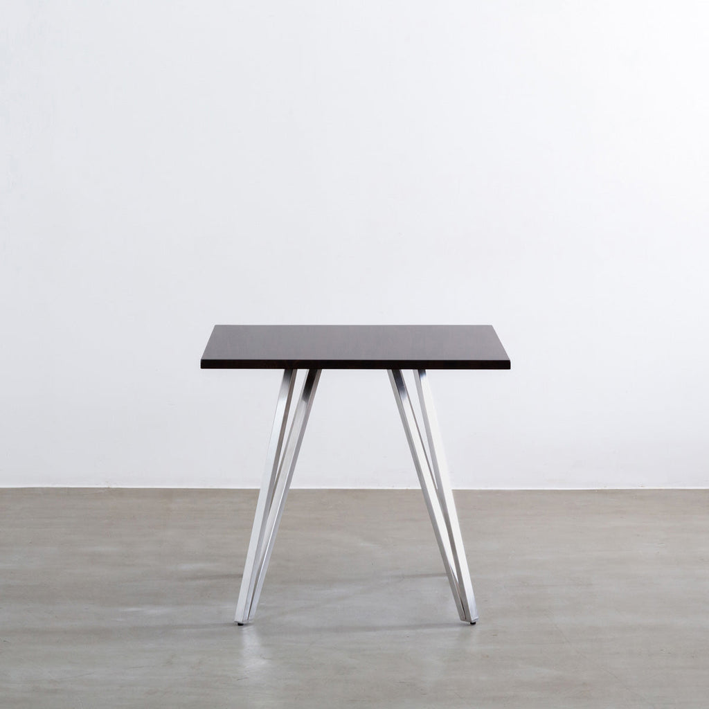 Gemoneのラバーウッドブラックブラウンのスクエア天板と三角のチューブが華やかなステンレス脚4本を組み合わせたカフェテーブル（正面）