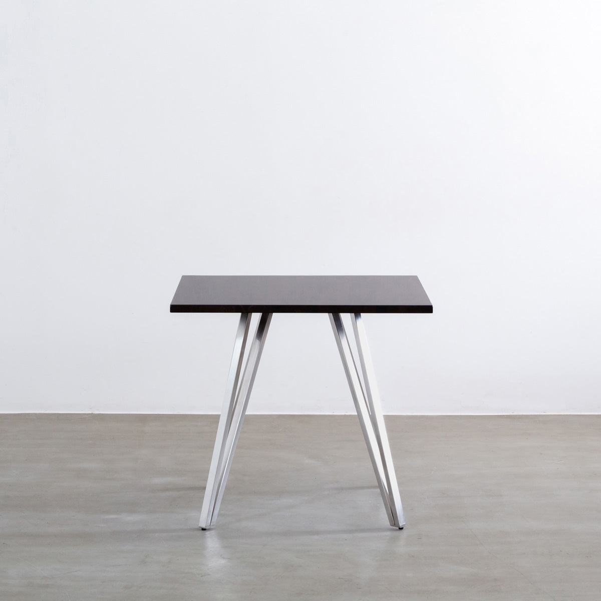 Gemoneのラバーウッドブラックブラウンのスクエア天板と三角のチューブが華やかなステンレス脚4本を組み合わせたカフェテーブル（正面）