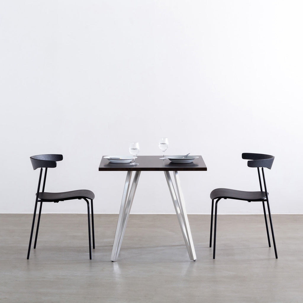 Gemoneのラバーウッドブラックブラウンのスクエア天板と三角のチューブが華やかなステンレス脚4本を組み合わせたカフェテーブル（使用例1）