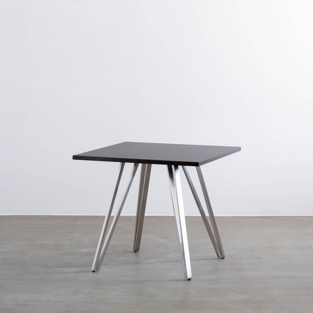 Gemoneのラバーウッドブラックブラウンのスクエア天板と三角のチューブが華やかなステンレス脚4本を組み合わせたカフェテーブル