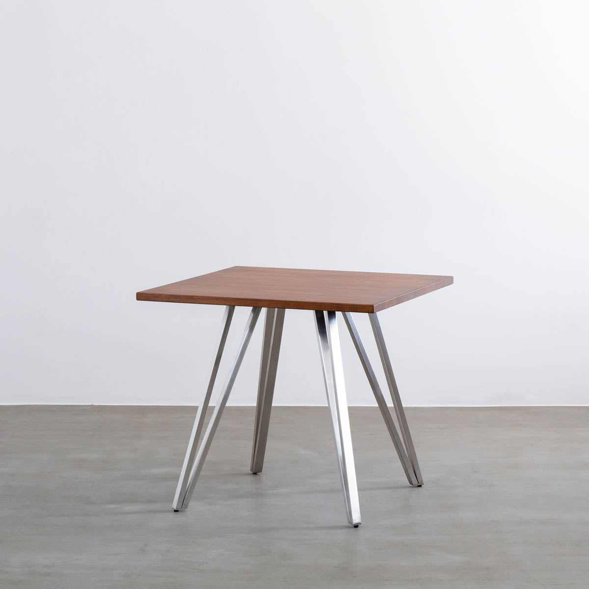 Gemoneのラバーウッドチークブラウンのスクエア天板と三角のチューブが華やかなステンレス脚4本を組み合わせたカフェテーブル