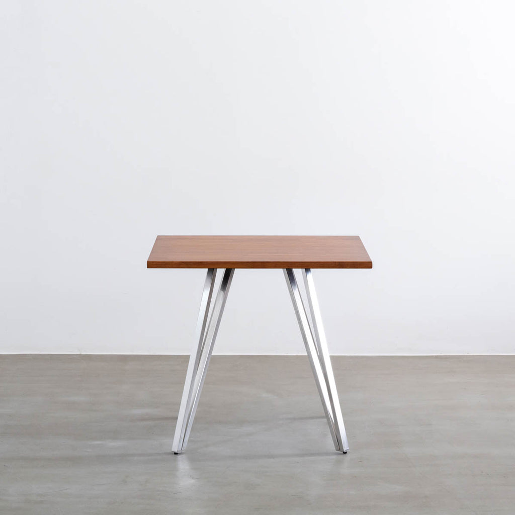 Gemoneのラバーウッドチークブラウンのスクエア天板と三角のチューブが華やかなステンレス脚4本を組み合わせたカフェテーブル（正面）