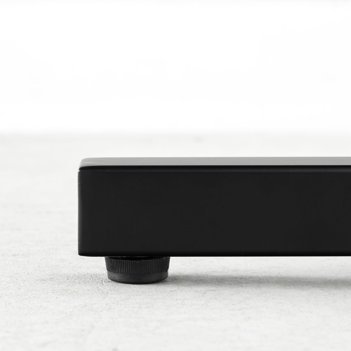 KANADEMONOのホワイトオーク突板天板とマットブラックのIライン鉄脚を組み合わせたシンプルモダンなテーブル（アジャスター部分）