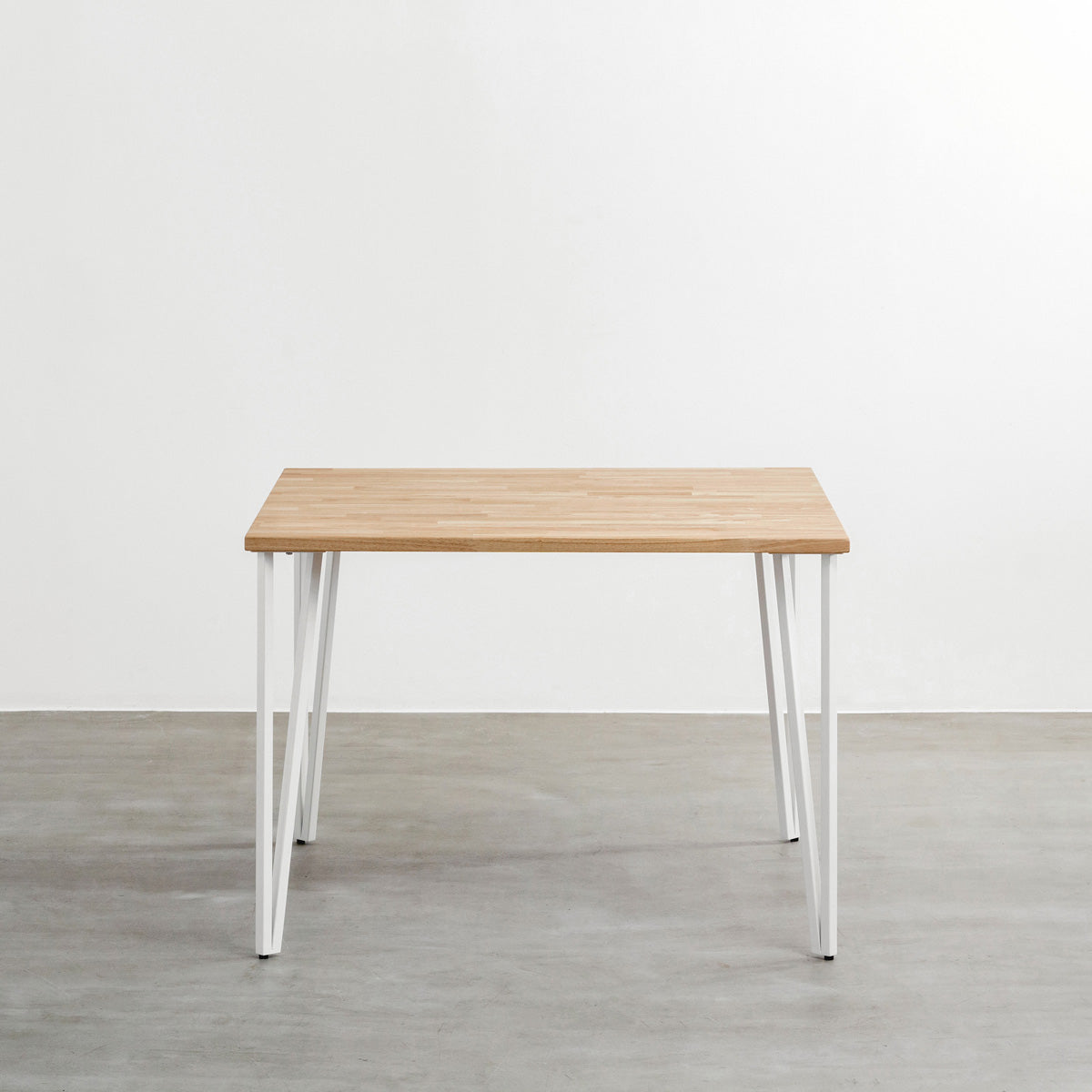 かなでもののラバーウッドAshGray天板とトライアングルStraightホワイト脚4本を組み合わせた100cmスクエア型のカフェテーブル（正面）