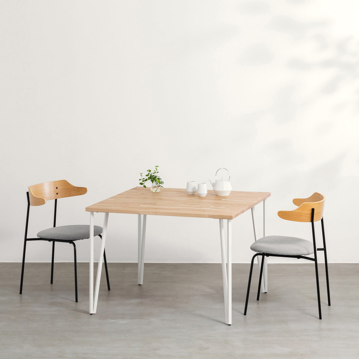 かなでもののラバーウッドAshGray天板とトライアングルStraightホワイト脚4本を組み合わせた100cmスクエア型のカフェテーブル（使用例）