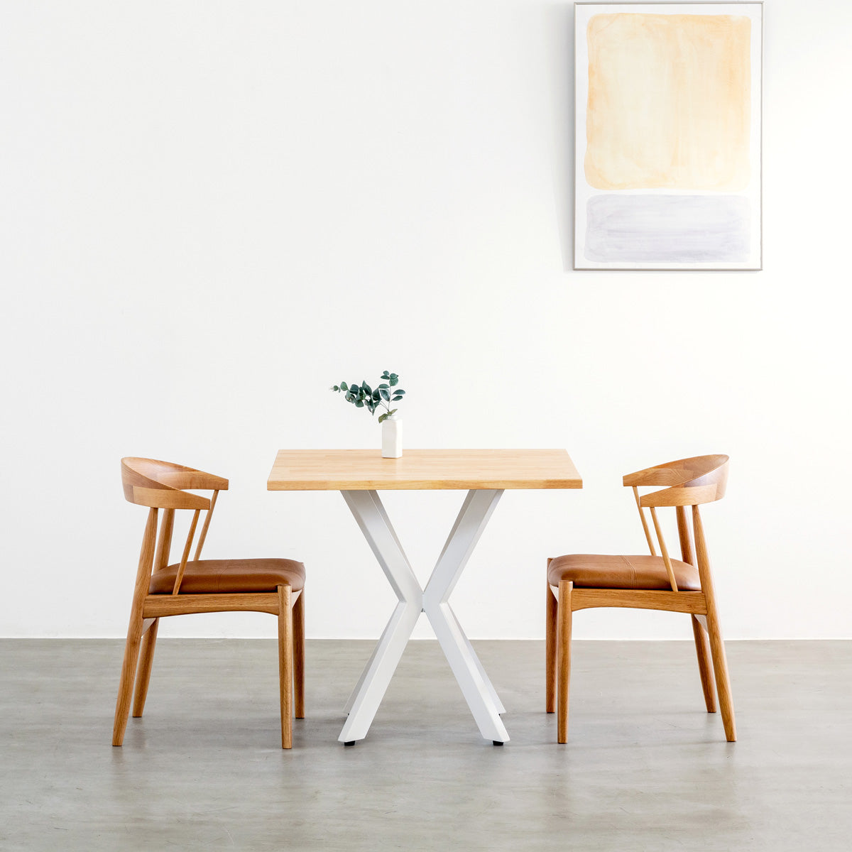 Kanademonoラバーウッドナチュラルのスクエア天板とデザイン性の高いXラインのホワイト脚を組み合わせたカフェテーブル（使用例）