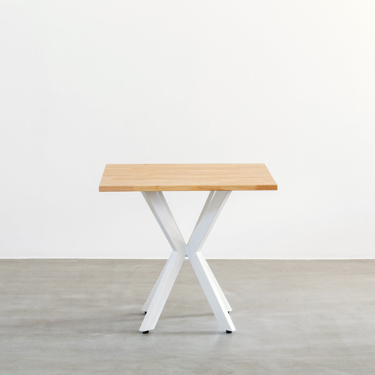Kanademonoラバーウッドナチュラルのスクエア天板とデザイン性の高いXラインのホワイト脚を組み合わせたカフェテーブル（正面）