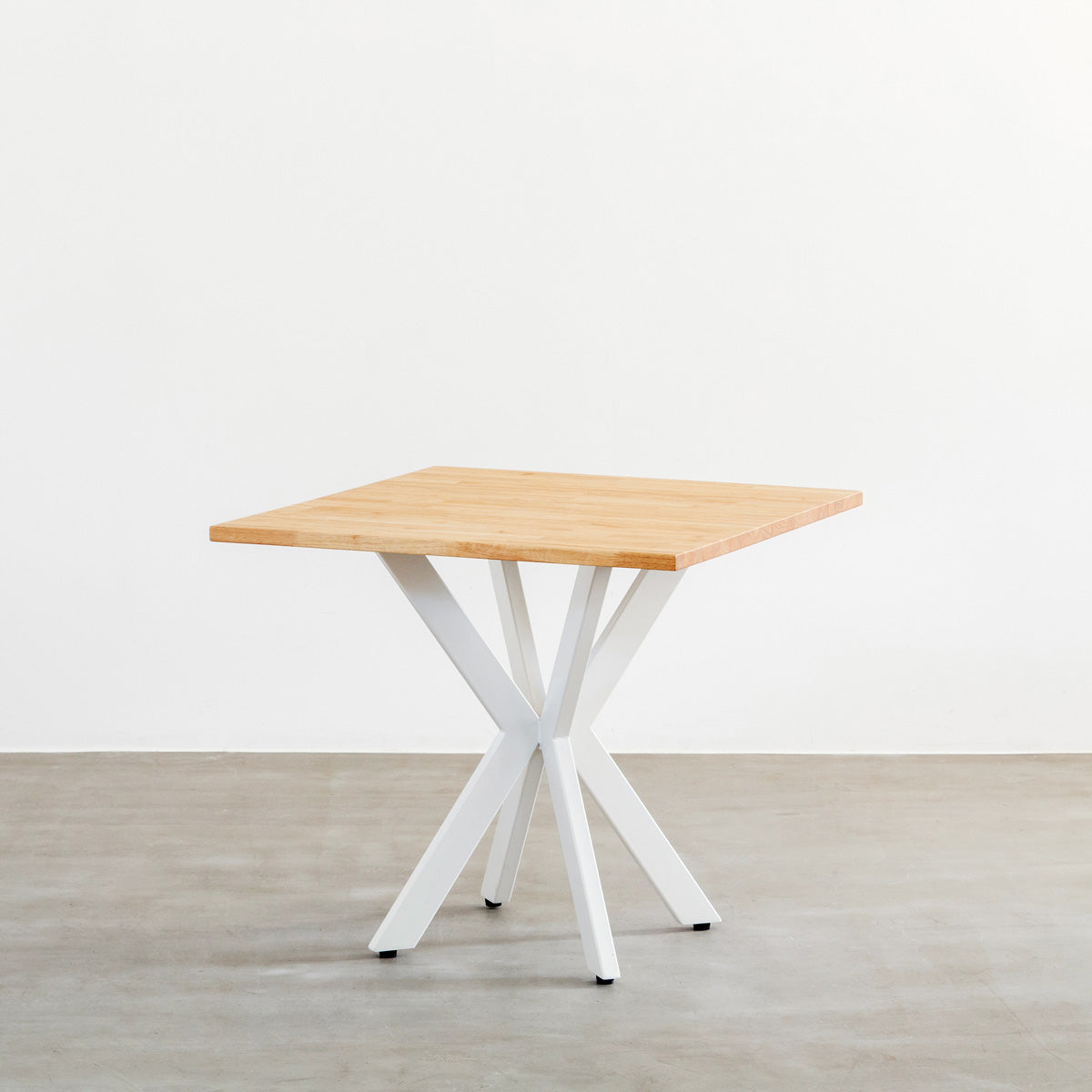 Kanademonoラバーウッドナチュラルのスクエア天板とデザイン性の高いXラインのホワイト脚を組み合わせたカフェテーブル