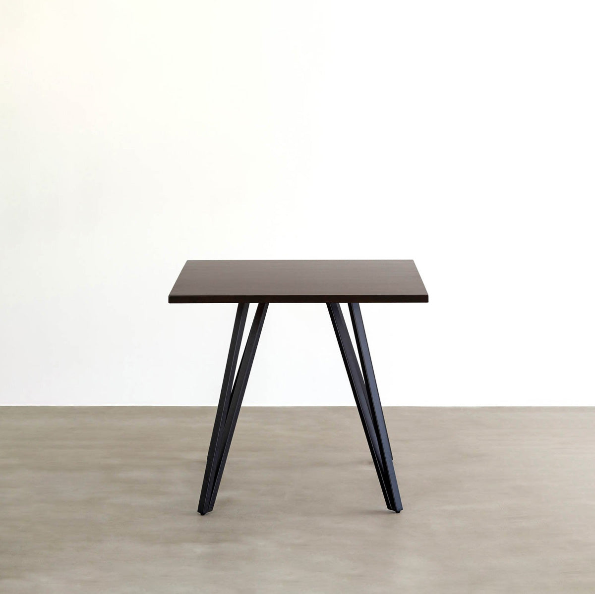 KANADEMONOのラバーウッド・ブラックブラウンのスクエア天板と三角のチューブが華やかなアイアン脚を組み合わせたカフェテーブル（正面）