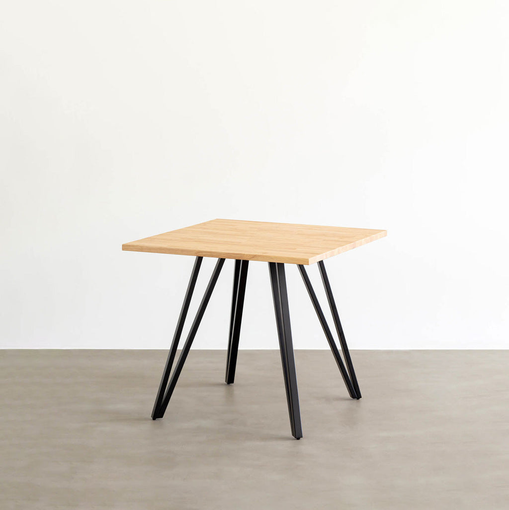 KANADEMONOのラバーウッド・ナチュラルのスクエア天板と三角のチューブが華やかなアイアン脚を組み合わせたカフェテーブル（斜め）