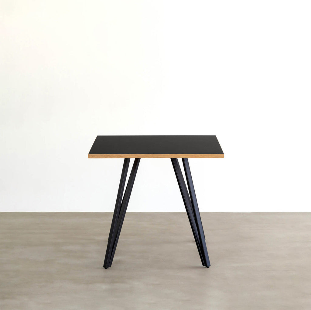 KANADEMONOのリノリウム・Neroのスクエア天板と三角のチューブが華やかなアイアン脚を組み合わせたカフェテーブル（正面）