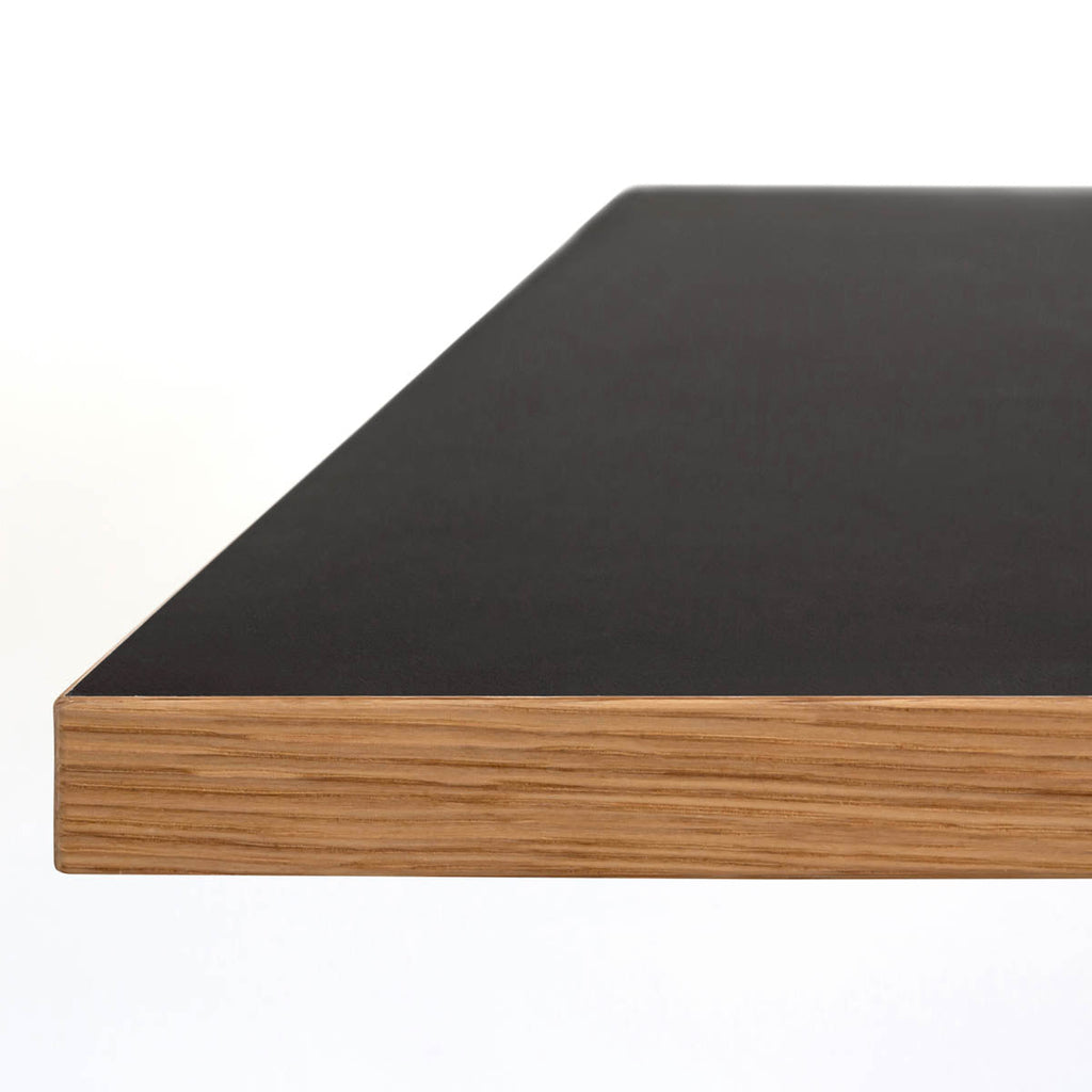 Kanademonoリノリウム・Neroのスクエア天板と三角のチューブが華やかなアイアン脚を組み合わせたカフェテーブル（天板の側面）