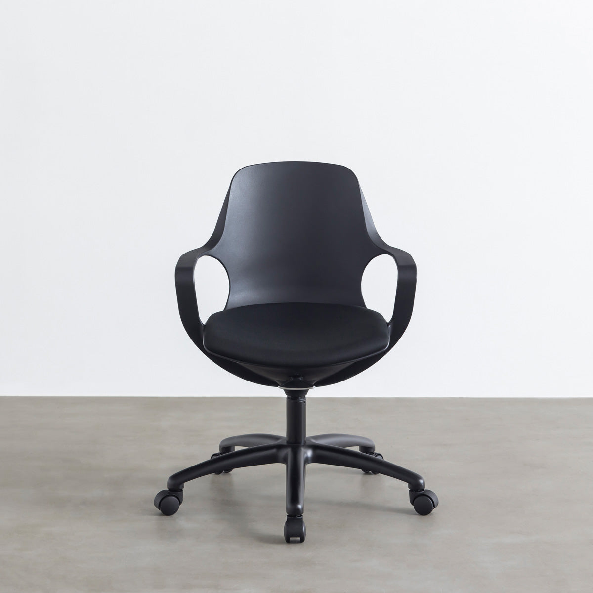 KANADEMONOの背もたれから座面までのなめらかなシルエットが特徴的なオールブラックの回転式デスクチェア(正面）