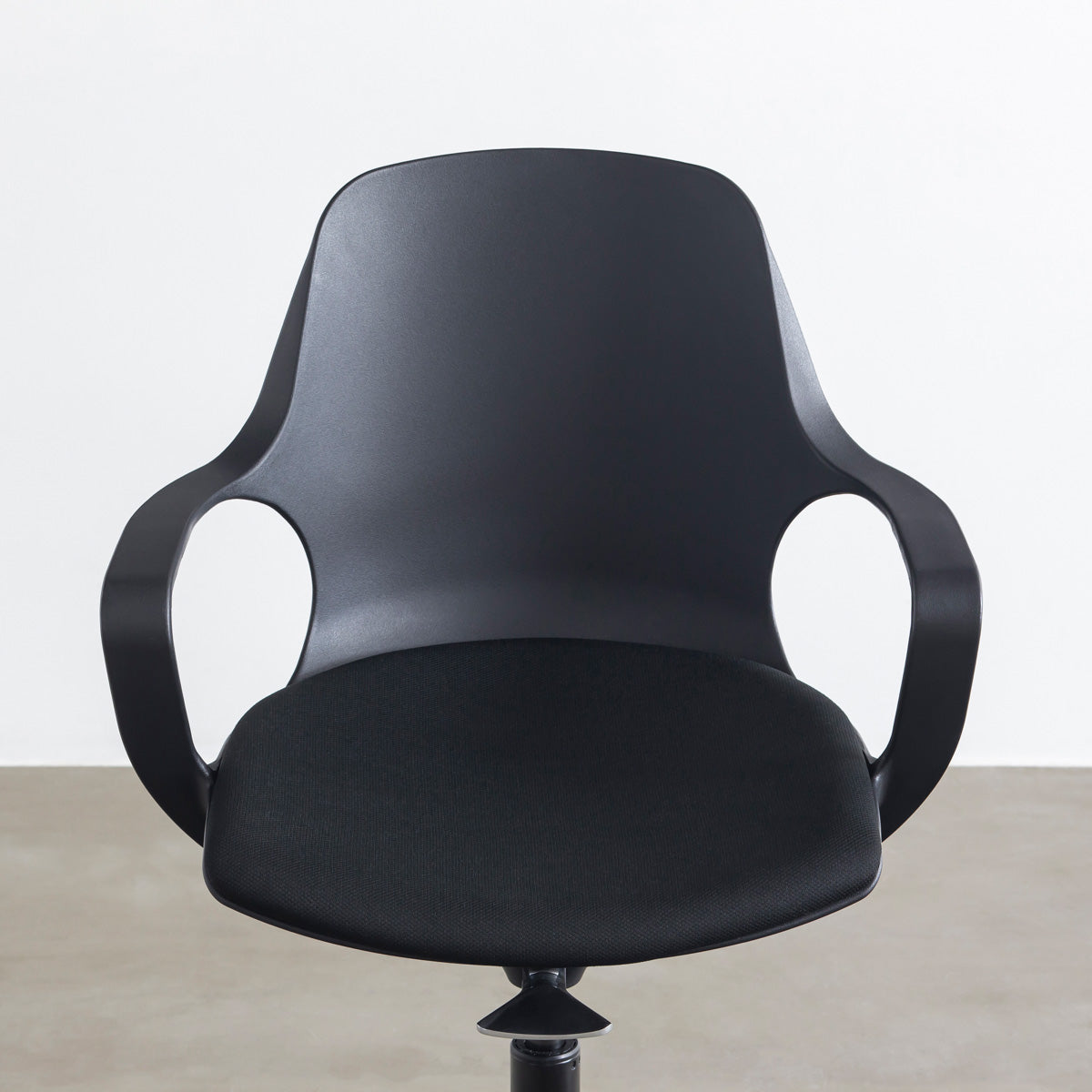 KANADEMONOの背もたれから座面までのなめらかなシルエットが特徴的なオールブラックの回転式デスクチェア(正面近影)