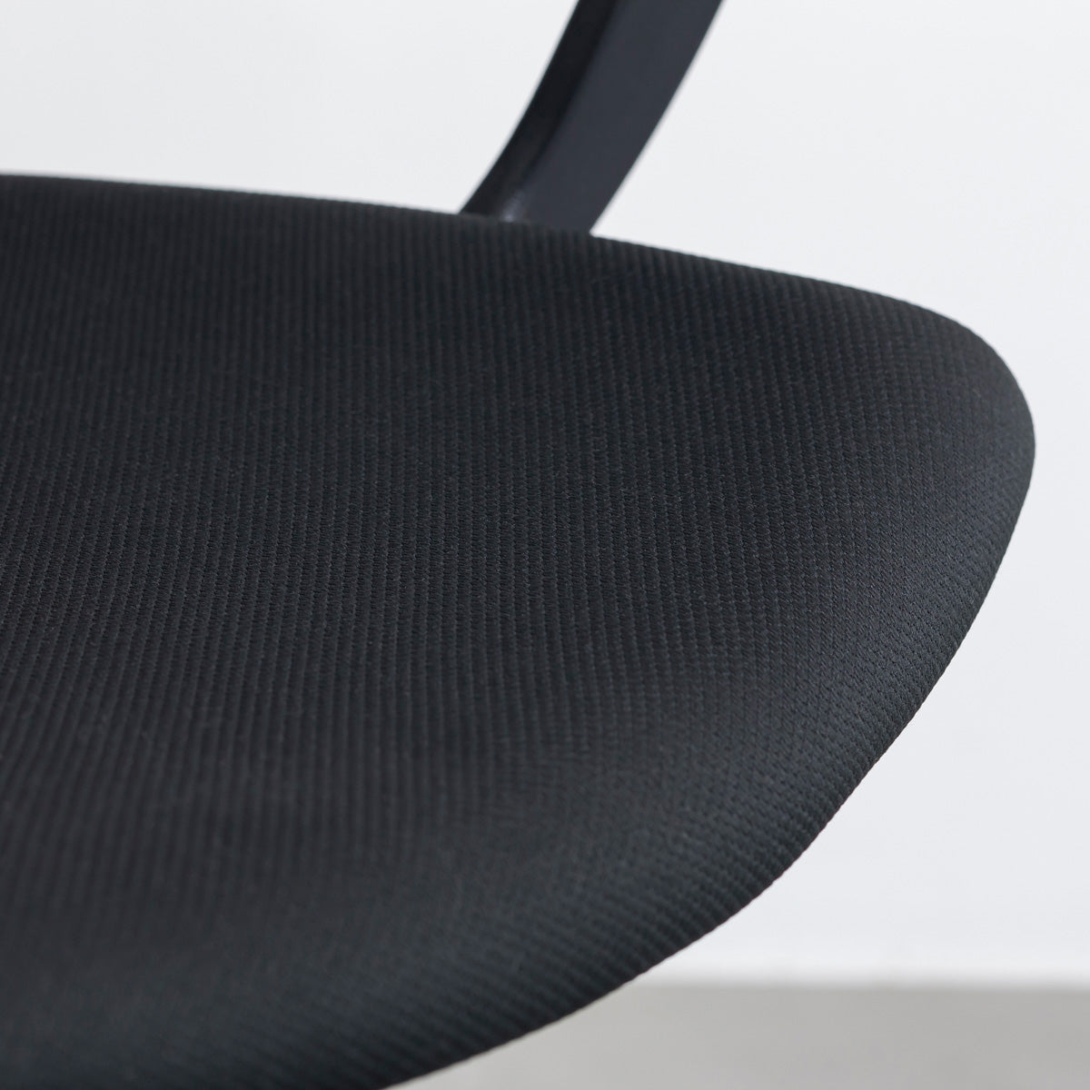 KANADEMONOの背もたれから座面までのなめらかなシルエットが特徴的なオールブラックの回転式デスクチェア(座面)