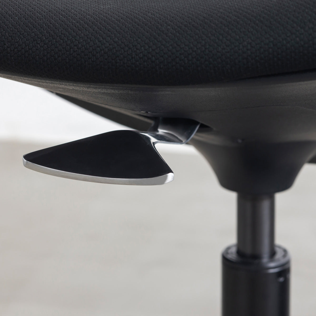 KANADEMONOの背もたれから座面までのなめらかなシルエットが特徴的なオールブラックの回転式デスクチェア(昇降レバー)