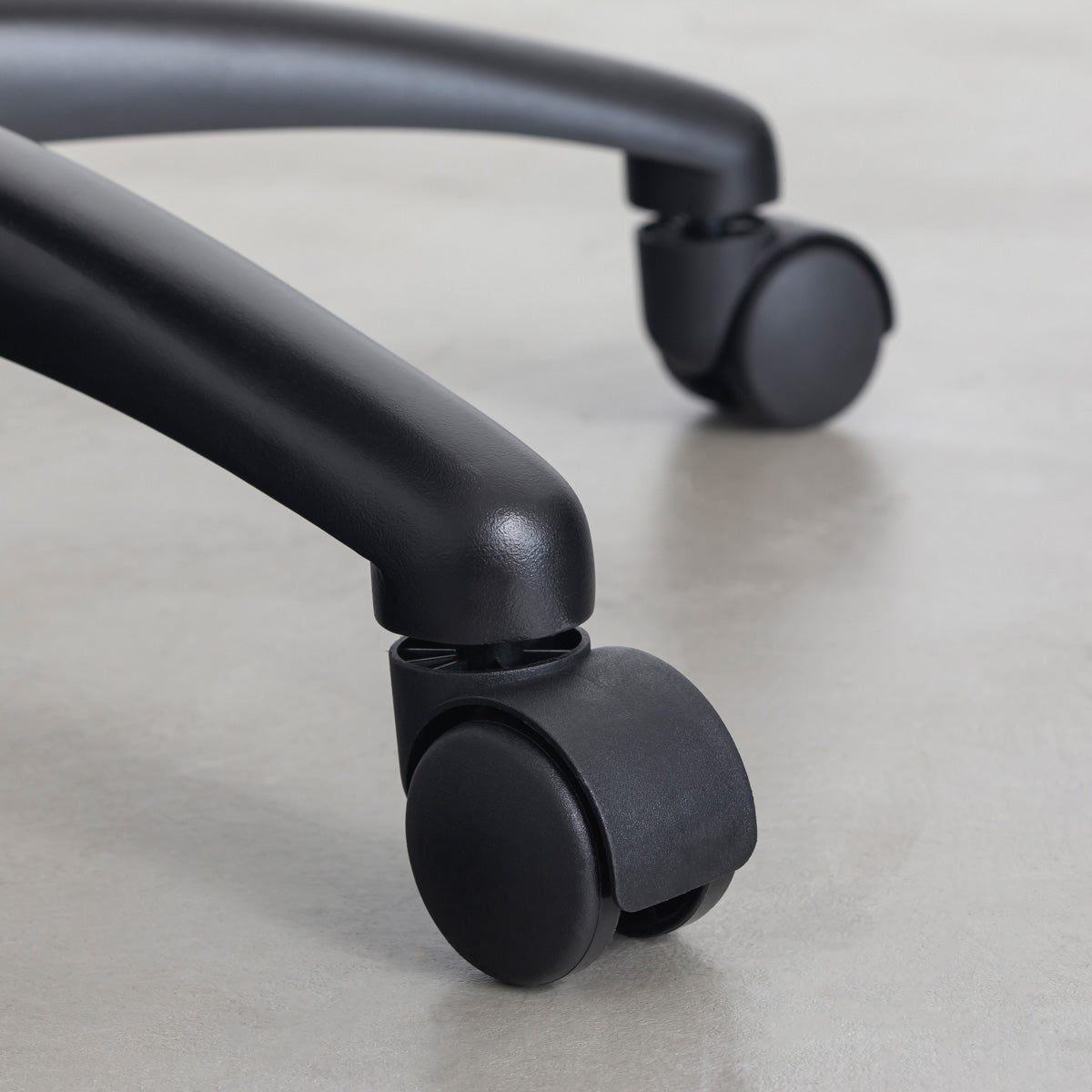 KANADEMONOの背もたれから座面までのなめらかなシルエットが特徴的なオールブラックの回転式デスクチェア(キャスター)