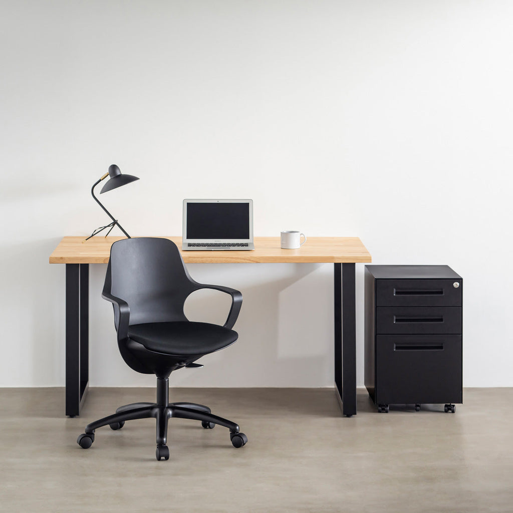 KANADEMONOの背もたれから座面までのなめらかなシルエットが特徴的なオールブラックの回転式デスクチェアの使用例1