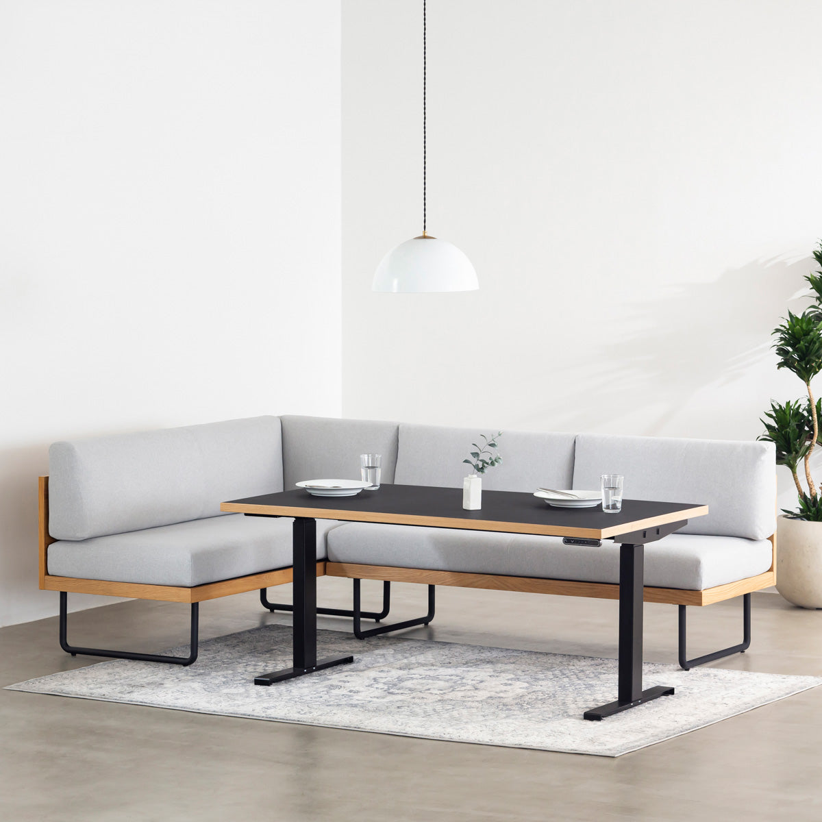 ファニチャーリノリウム素材のNero天板と、ブラックの電動昇降脚を組み合わせた、デザイン性も機能性もスマートなテーブル（ダイニング使用例）