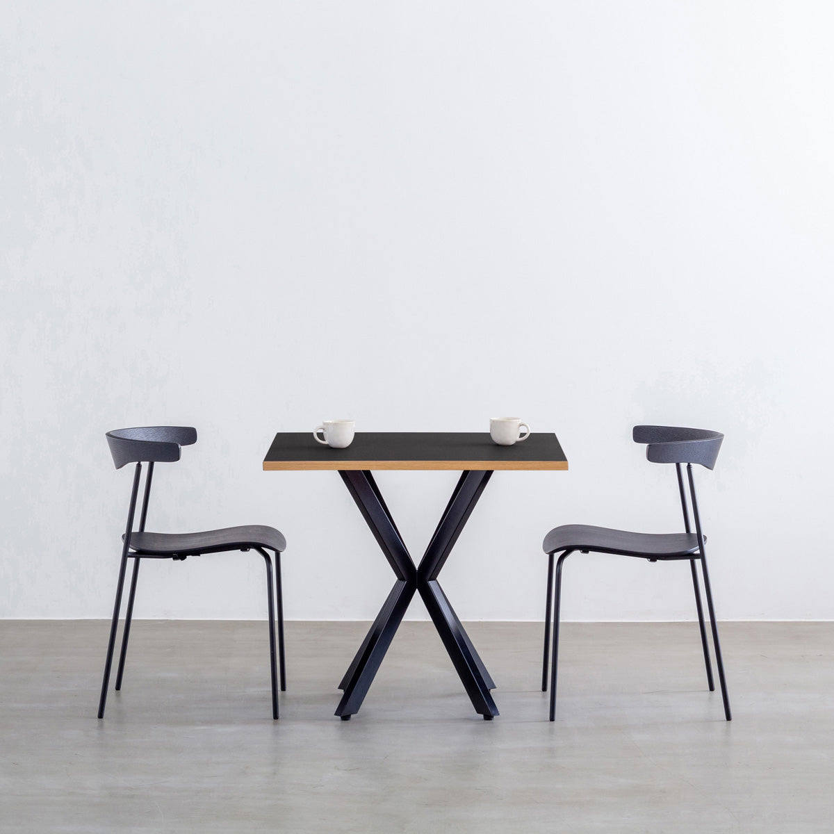 Kanademonoリノリウム Neroのスクエア天板とデザイン性の高いXラインの脚を組み合わせたカフェテーブルの使用例1