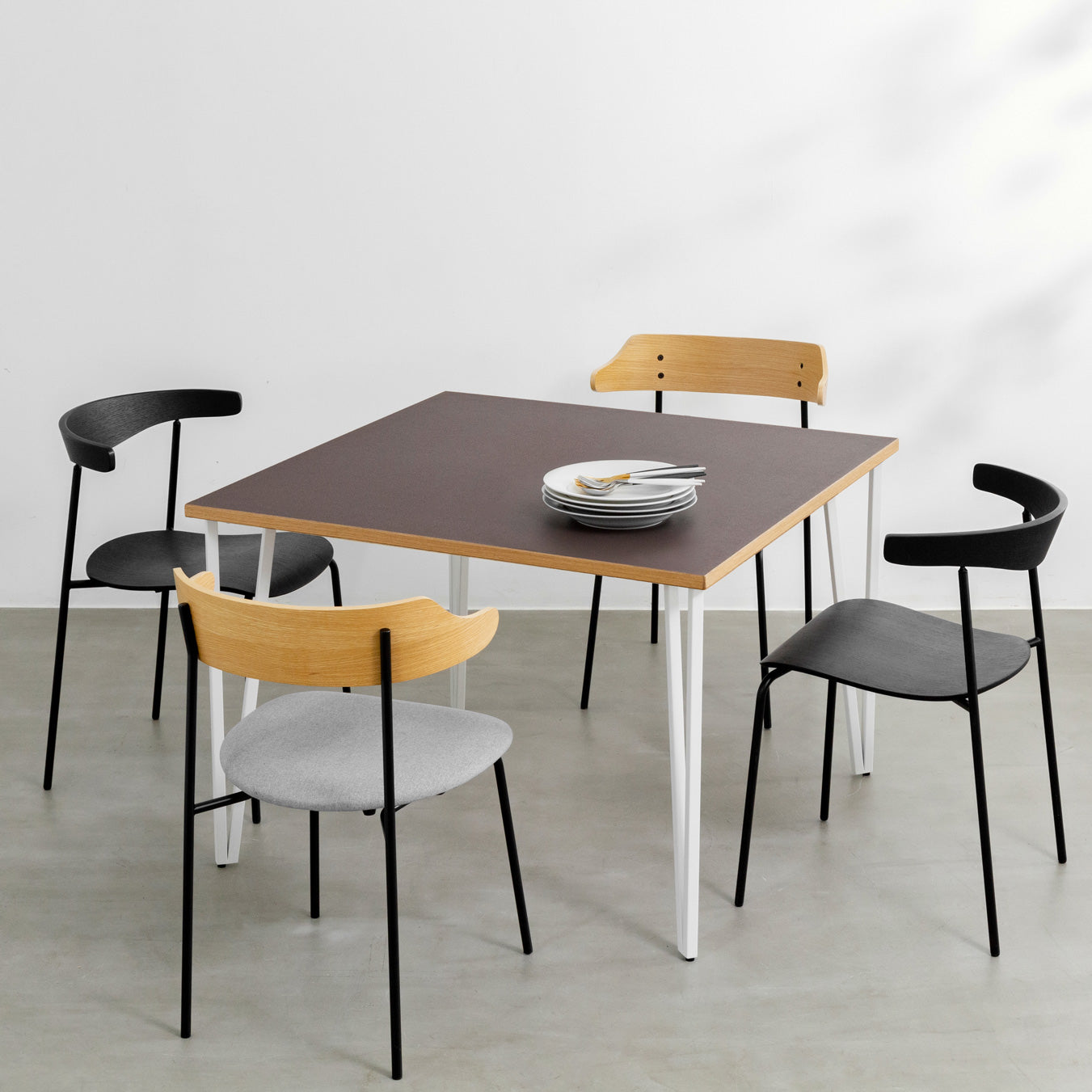 KANADEMONOのリノリウムMauve天板とトライアングルStraightホワイト脚4本を組み合わせた100cmスクエア型のカフェテーブル（使用例）