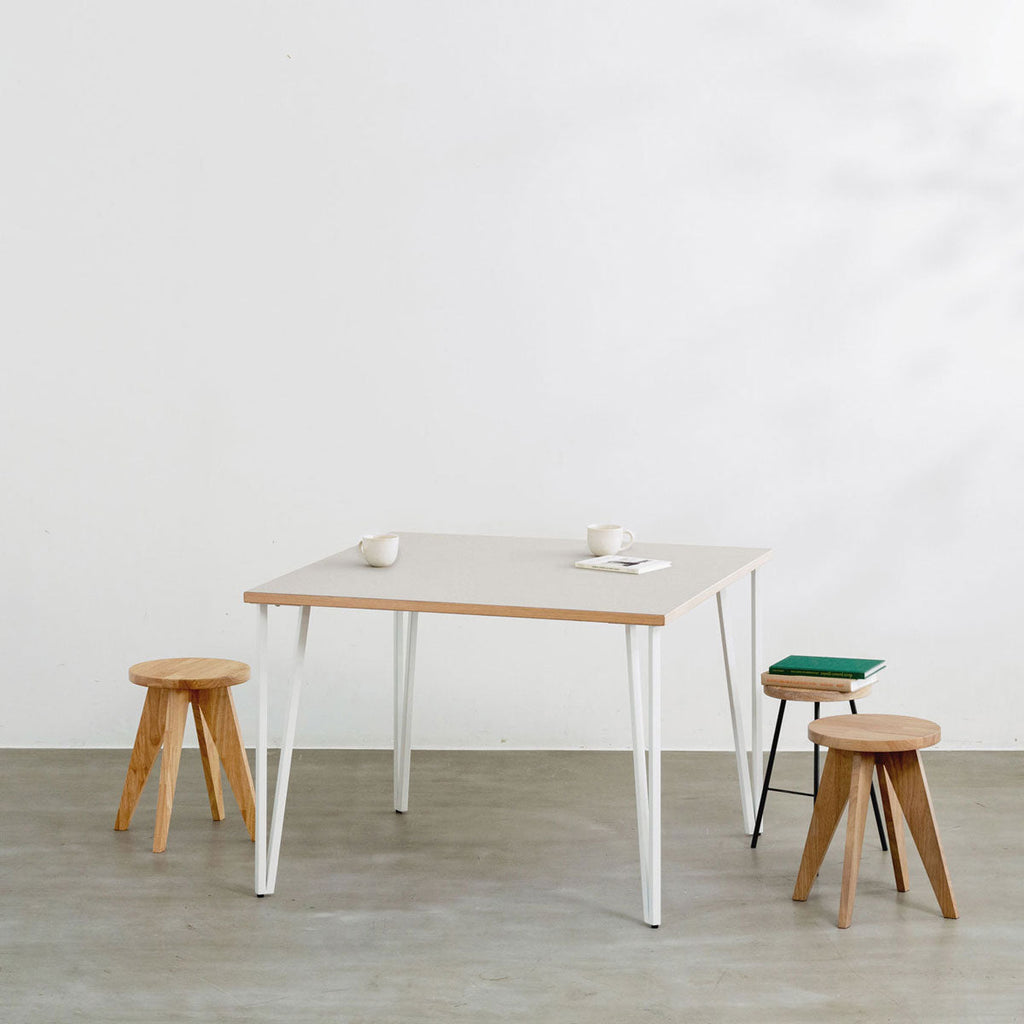 KANADEMONOのリノリウムMushroom天板とトライアングルStraightホワイト脚4本を組み合わせた100cmスクエア型のカフェテーブル（使用例）