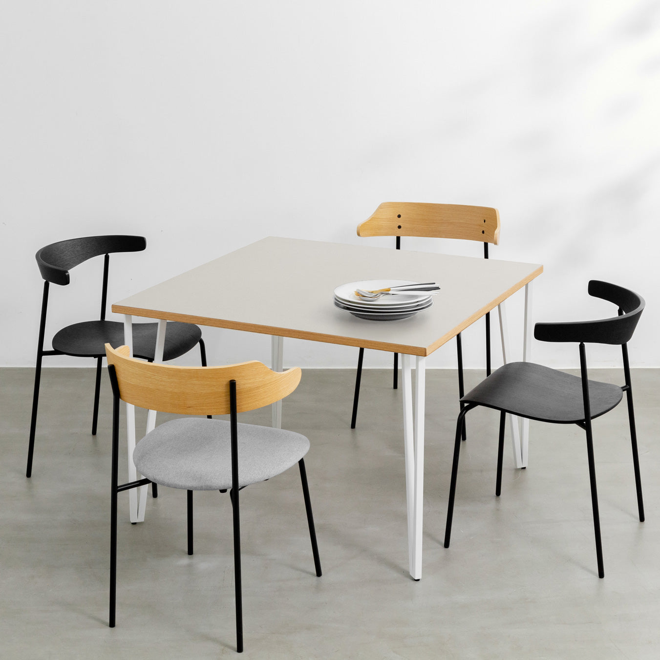 KANADEMONOのリノリウムMushroom天板とトライアングルStraightホワイト脚4本を組み合わせた100cmスクエア型のカフェテーブル（使用例2）