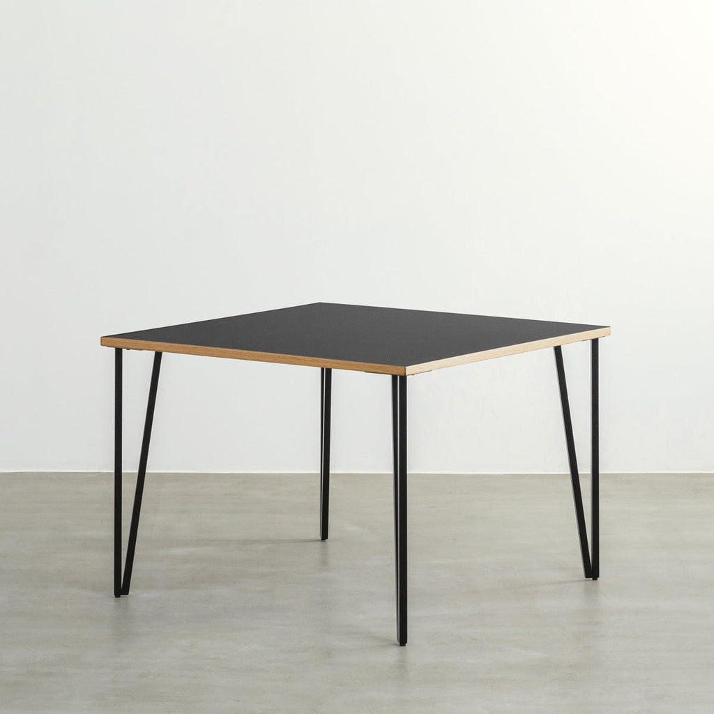 KANADEMONOのリノリウムNero天板とブラックトライアングルピン4本を組み合わせた一辺100cmスクエア型のカフェテーブル