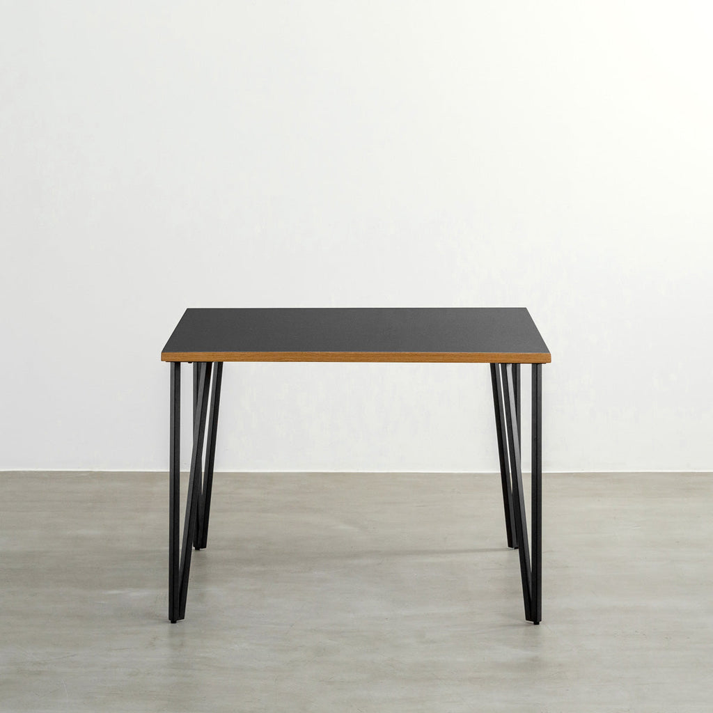 KANADEMONOのリノリウムNero天板とブラックトライアングルピン4本を組み合わせた一辺100cmスクエア型のカフェテーブル（正面）