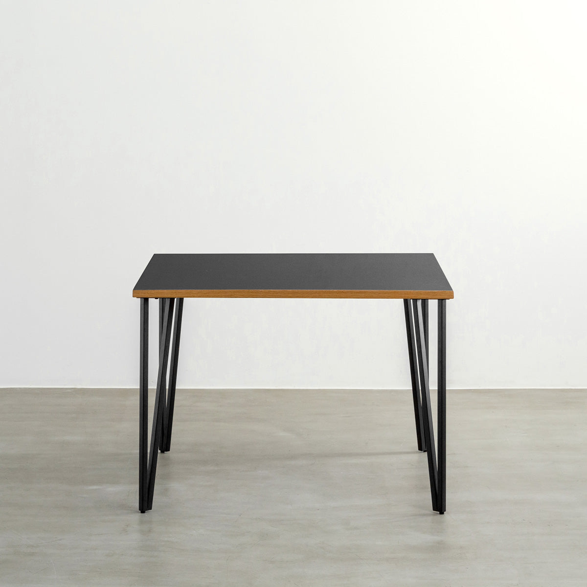 KANADEMONOのリノリウムNero天板とブラックトライアングルピン4本を組み合わせた一辺100cmスクエア型のカフェテーブル（正面）