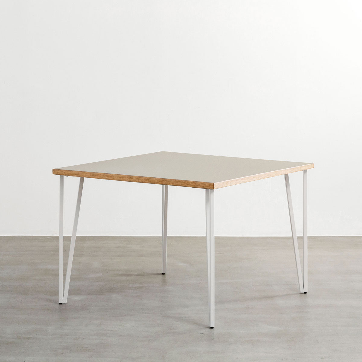 KANADEMONOのリノリウムPebble天板とトライアングルStraightホワイト脚4本を組み合わせた100cmスクエア型のカフェテーブル（斜め）